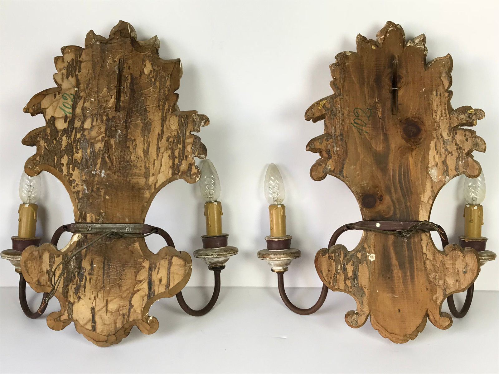 Paire d'appliques a 2 lumières en bois sculpté et patiné à décor de fleurs