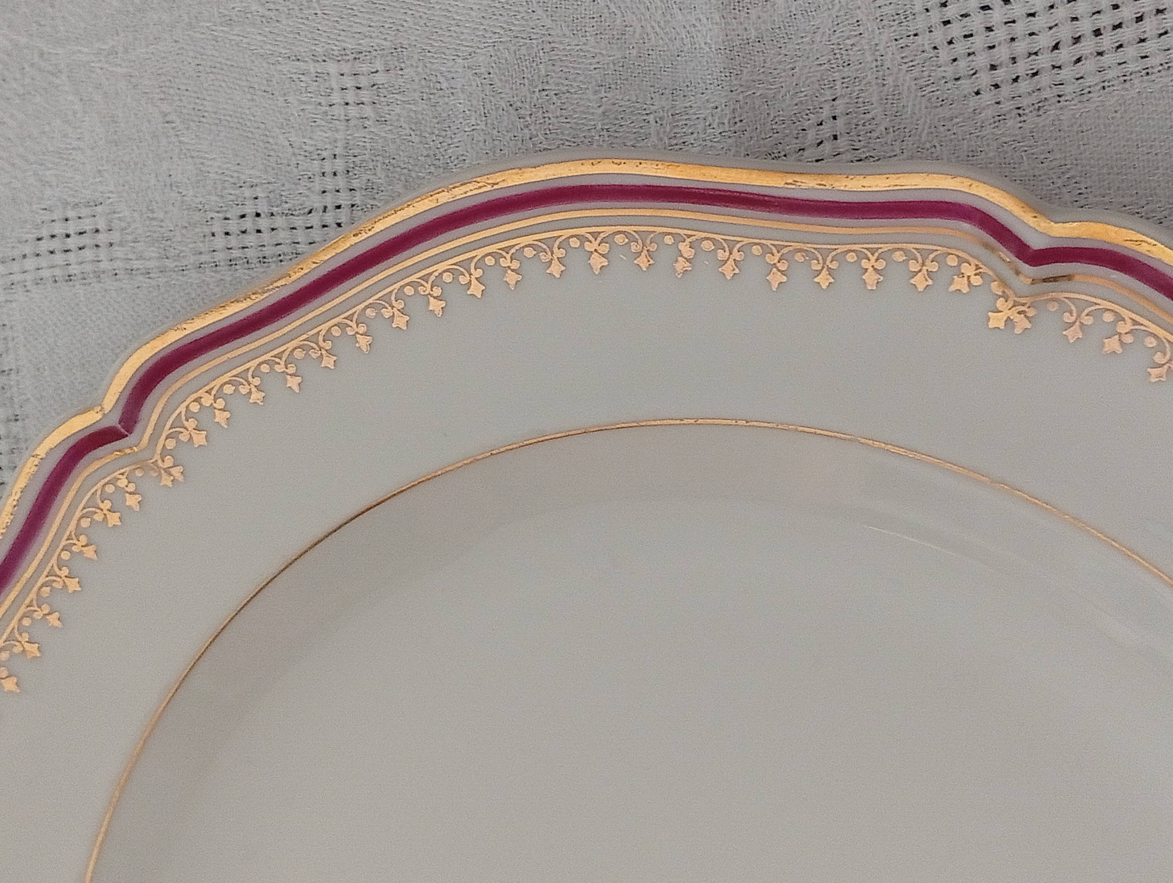 Set of 12 stylised white porcelain dinner plates, signed.