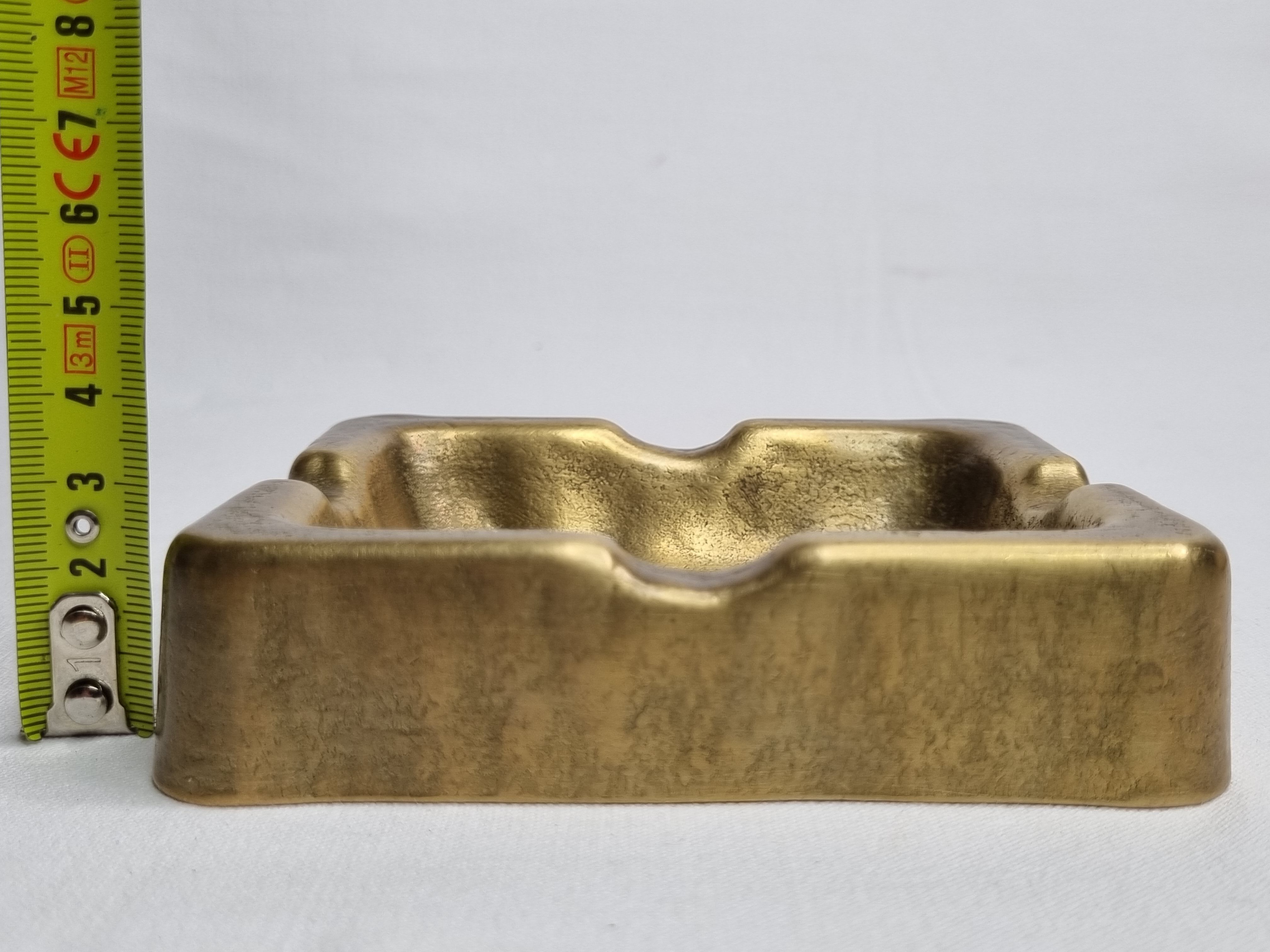 Empty pocket brutalist-inspired ashtray in gilded bronze