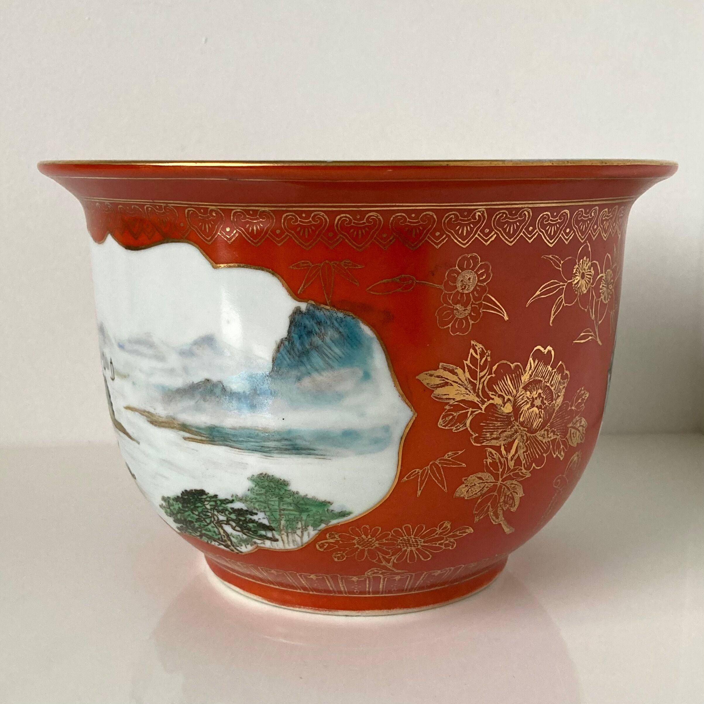 Chinese planter or Chinese porcelain pot cover decorated with landscapes on a coral and golden background
