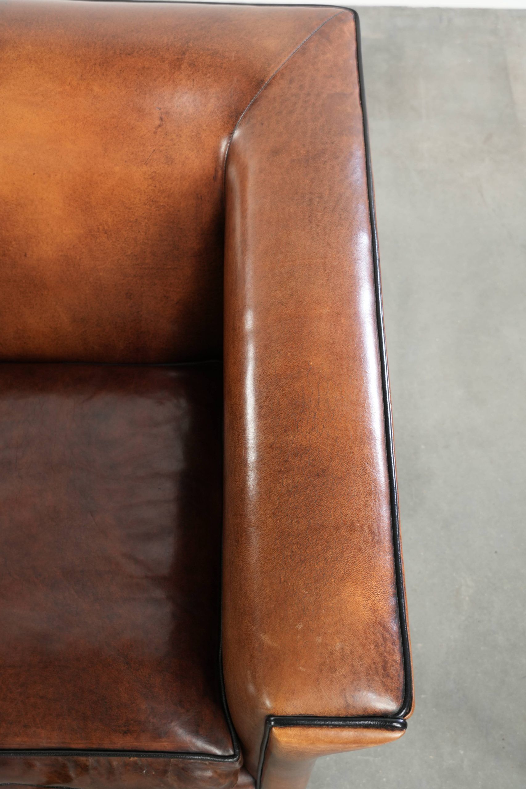 Ensemble de deux fauteuils en peau de mouton au design Art Déco avec passepoil noir.