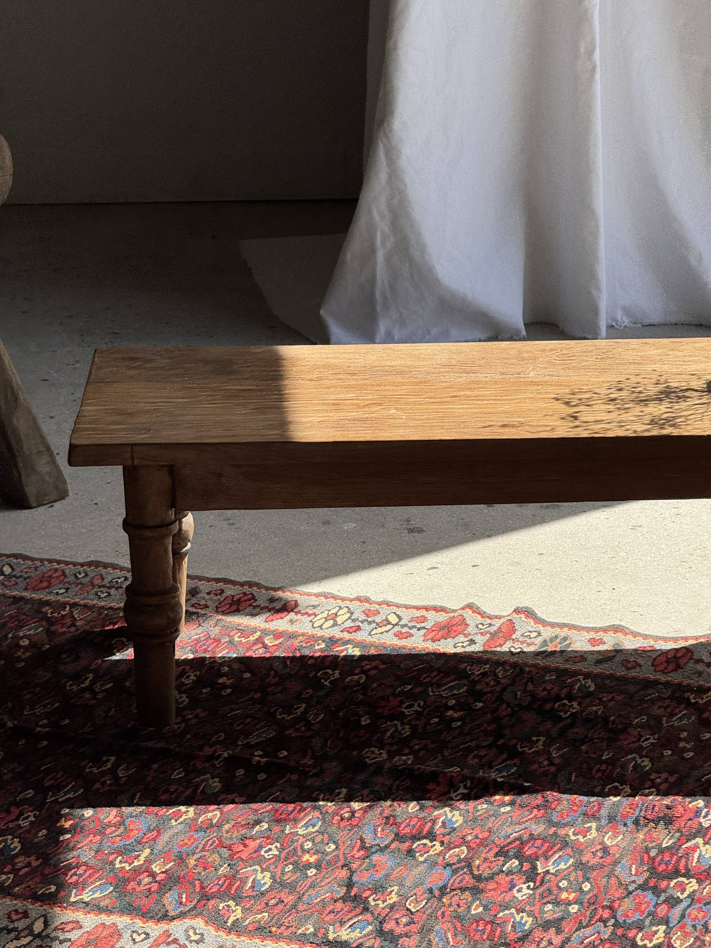 Brown Indonesian teak coffee table, with a border and cylindrical legs H40 L103.