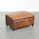 Characterful sheepskin footstool/ottoman finished with black piping