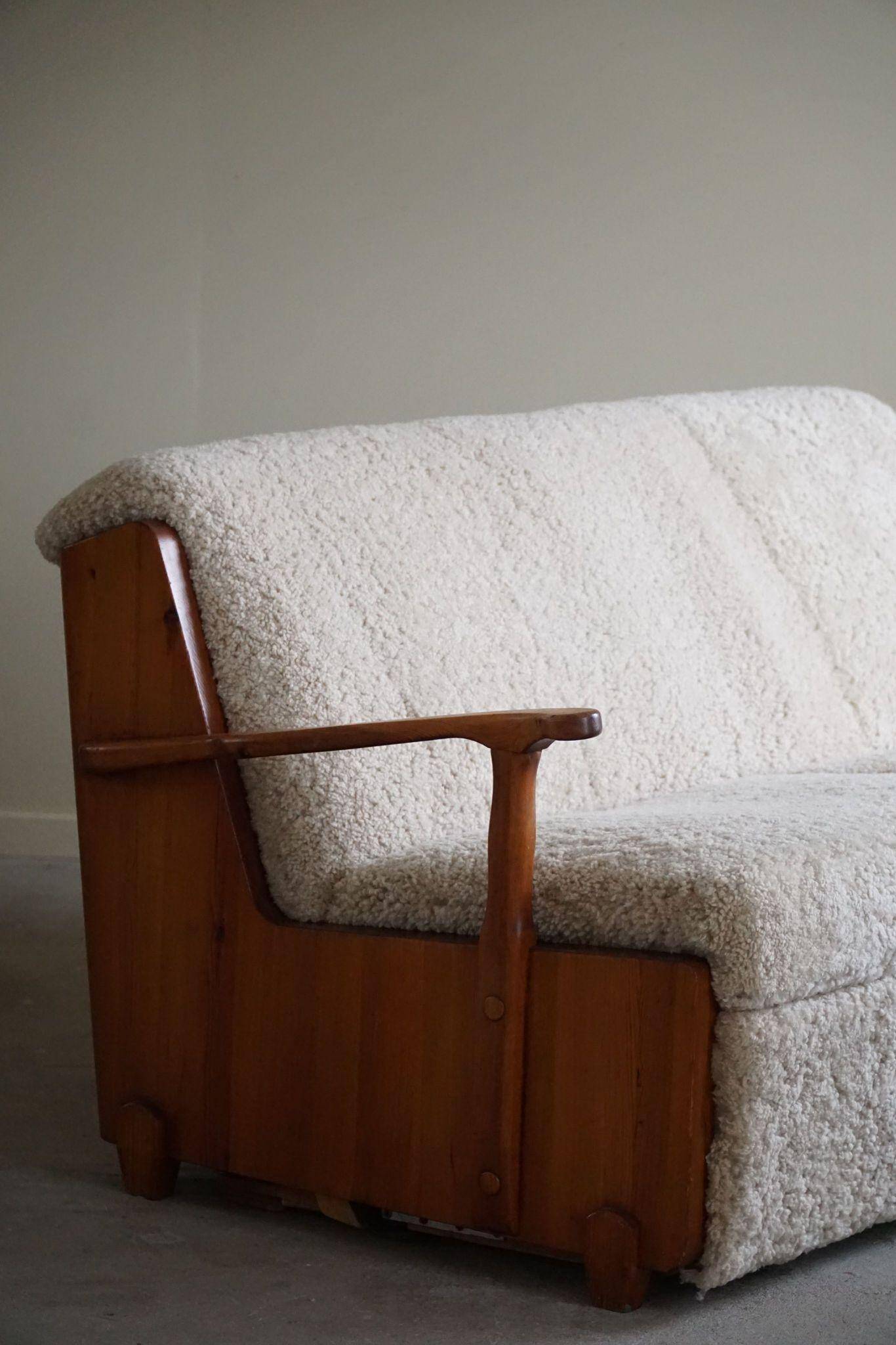 Modern Swedish two-seater independent sofa bed in pine and lambswool, 1950s.