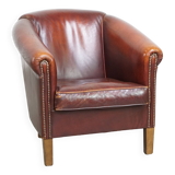Comfortable, rugged cognac-colored sheepskin club armchair with a characteristic seat cushion