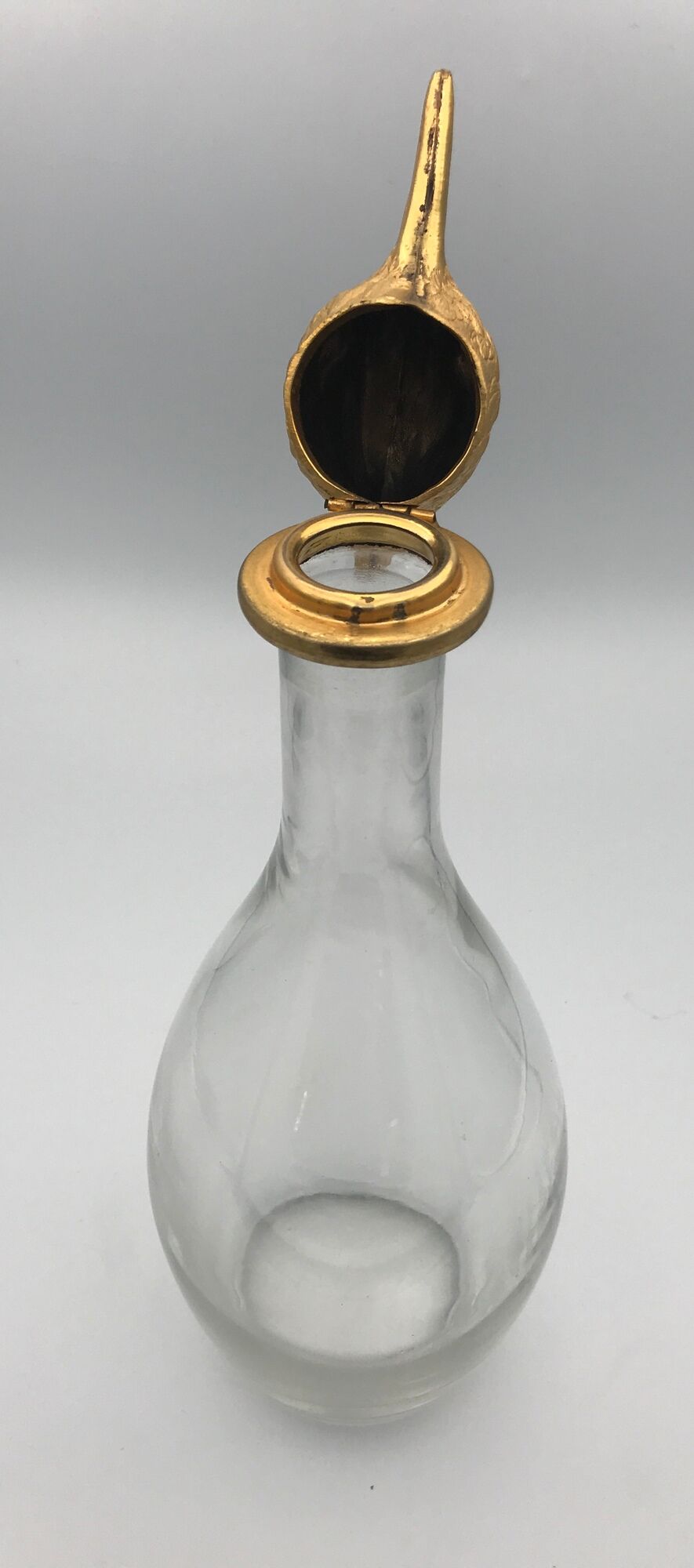 Glass bottle type carafe with gold metal bird head stopper