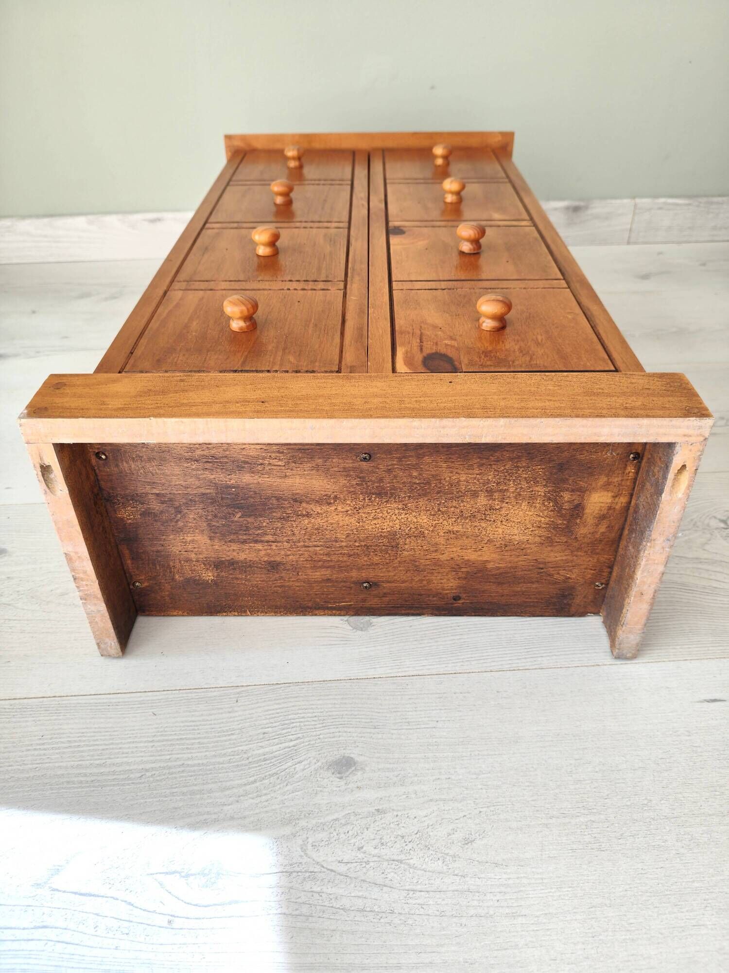 Small wooden piece of furniture, cabinet style, false drawers.