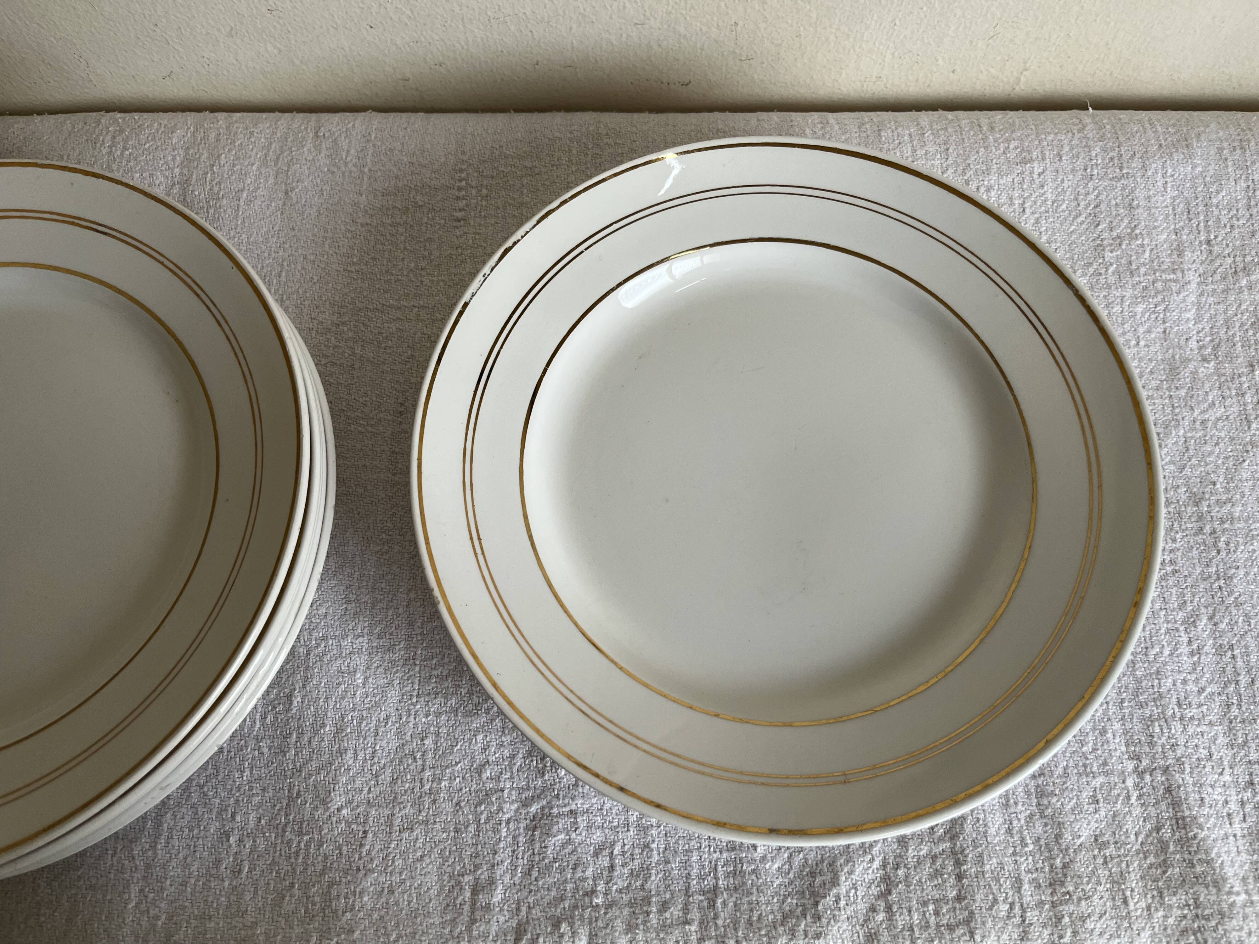 Set of 8 modernist flat plates in fine earthenware with pure gold trim, 1930.