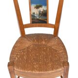 Pair of chairs with slatted backs and painted bands depicting animated landscapes.