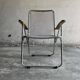 Pair of vintage silver aluminum wire folding chairs with wooden armrests — industrial minimalist