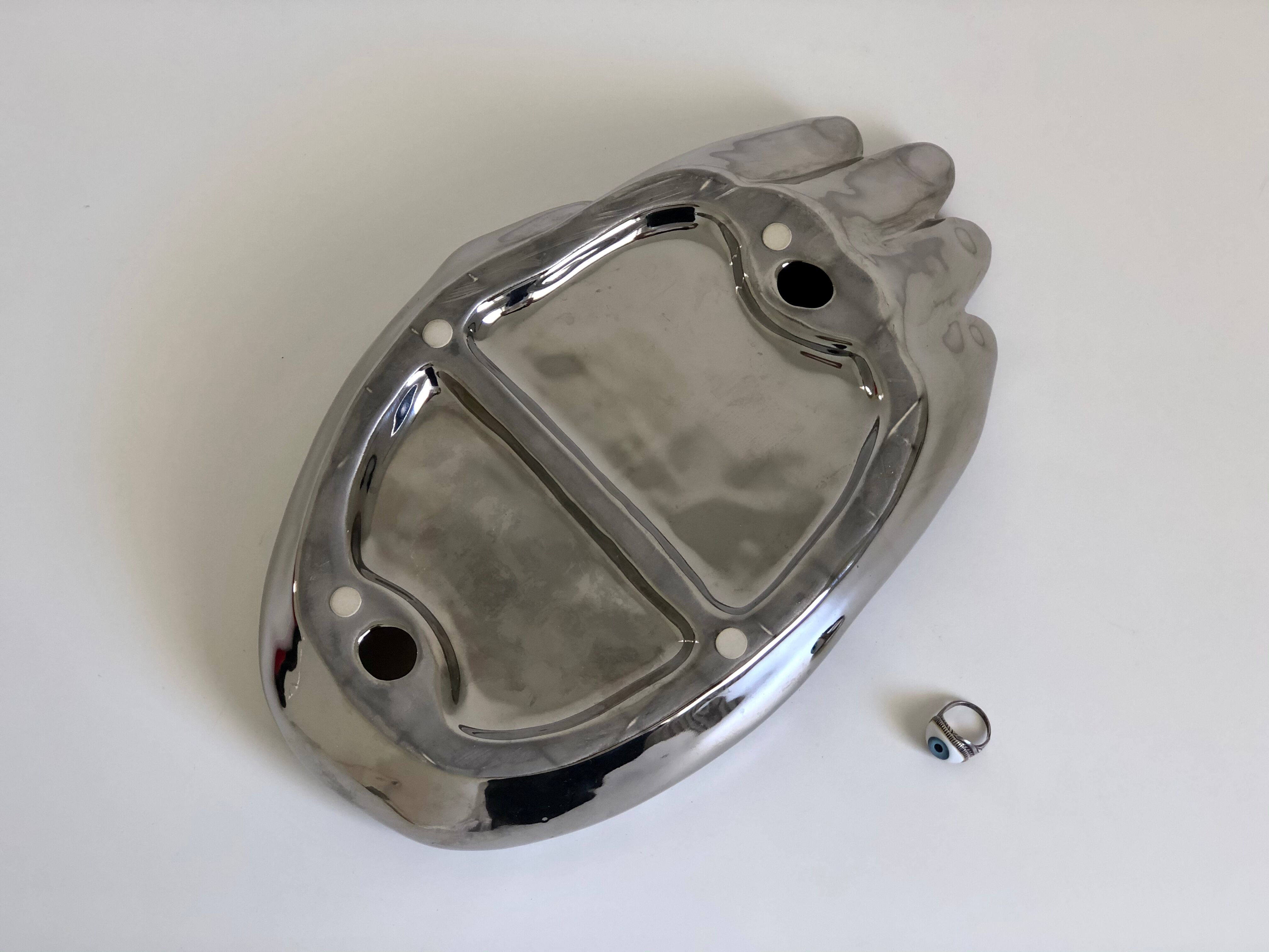 Empty silver chromed ceramic pocket in the shape of a large hand, 1980