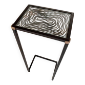 Black wrought iron side table with a transparent glass top.