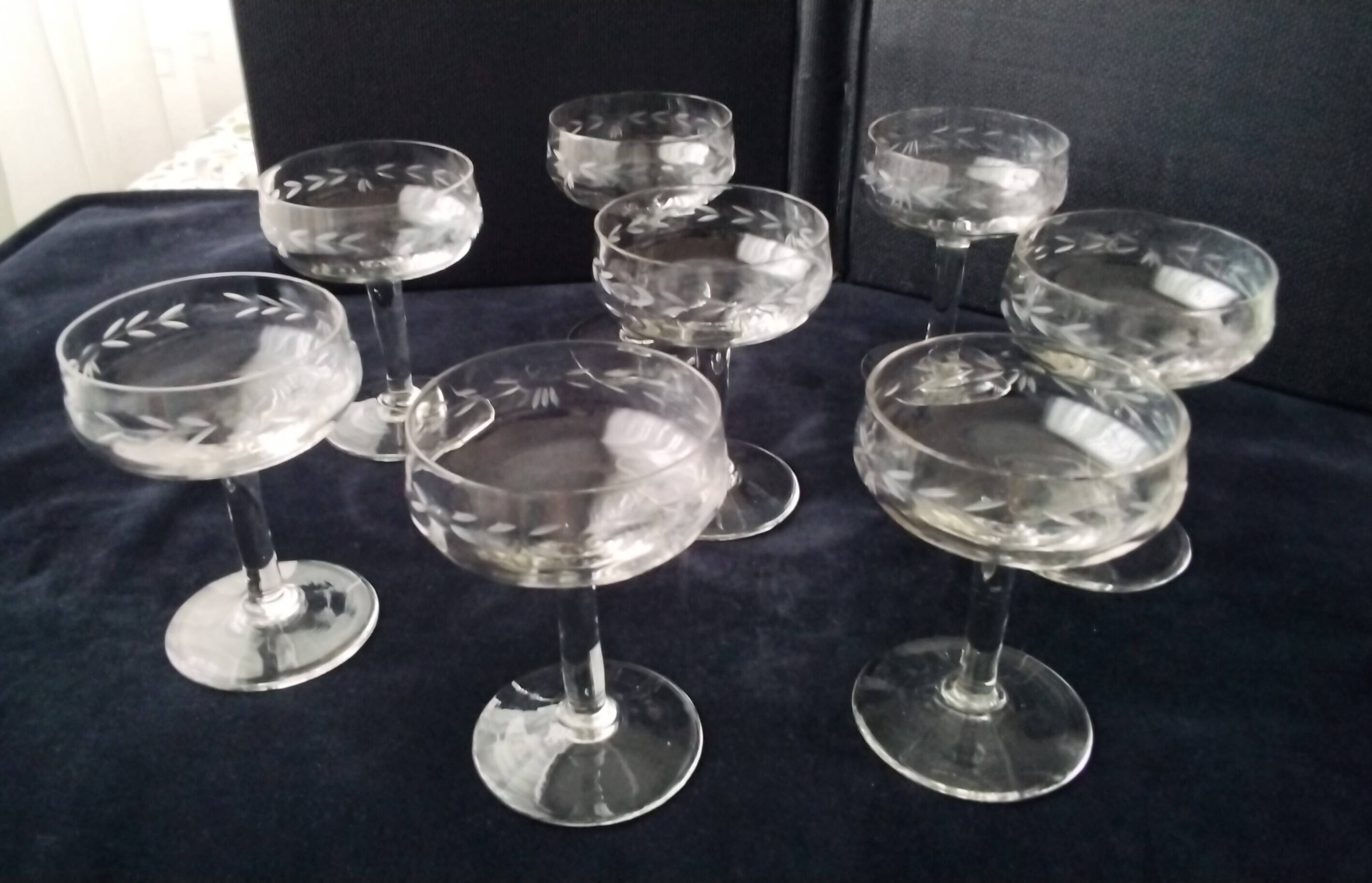 8 vintage glass champagne coupes with an engraved frieze decoration.