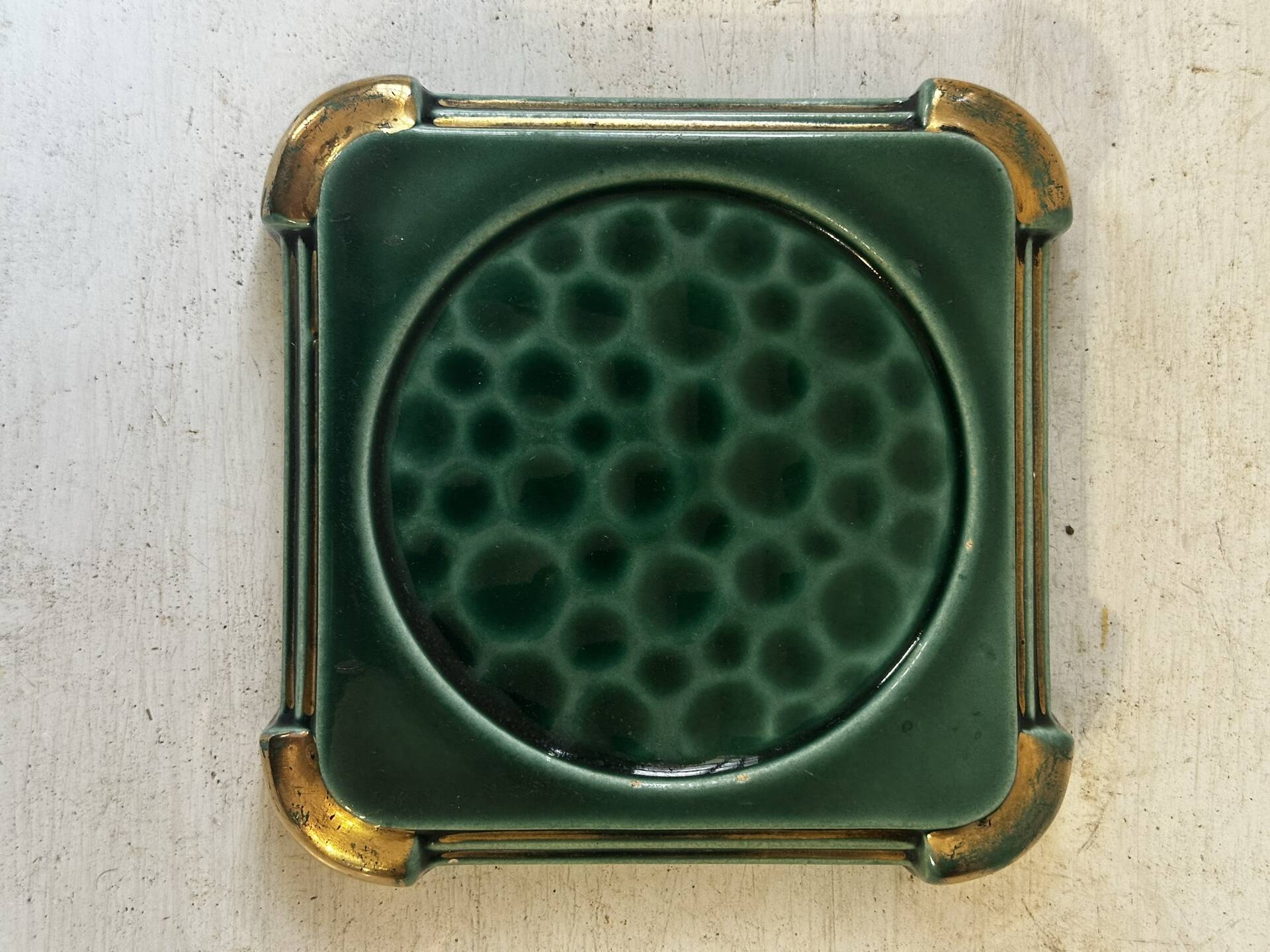Art Deco bottle coaster in speckled green glazed ceramic and
