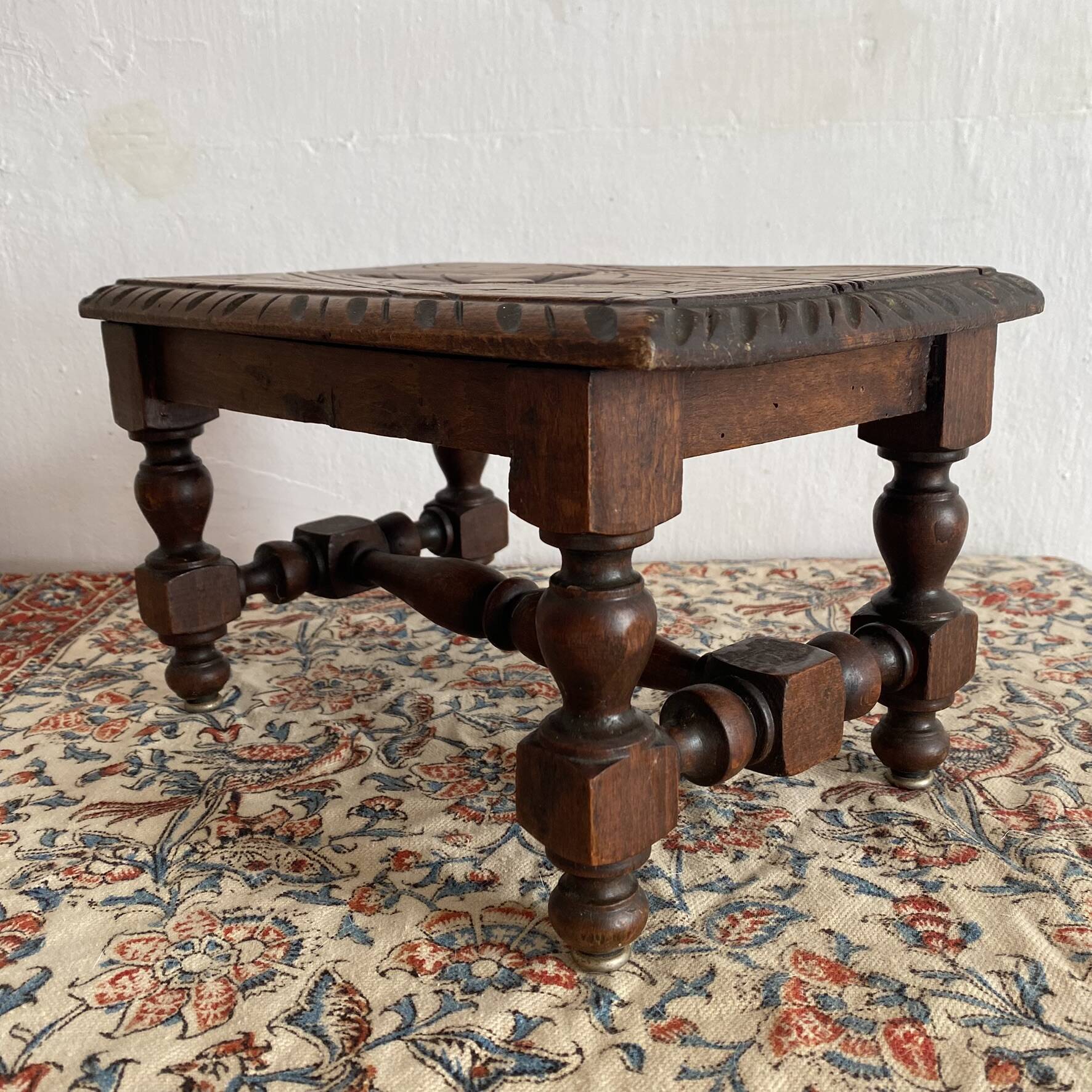 Low stool in carved wood