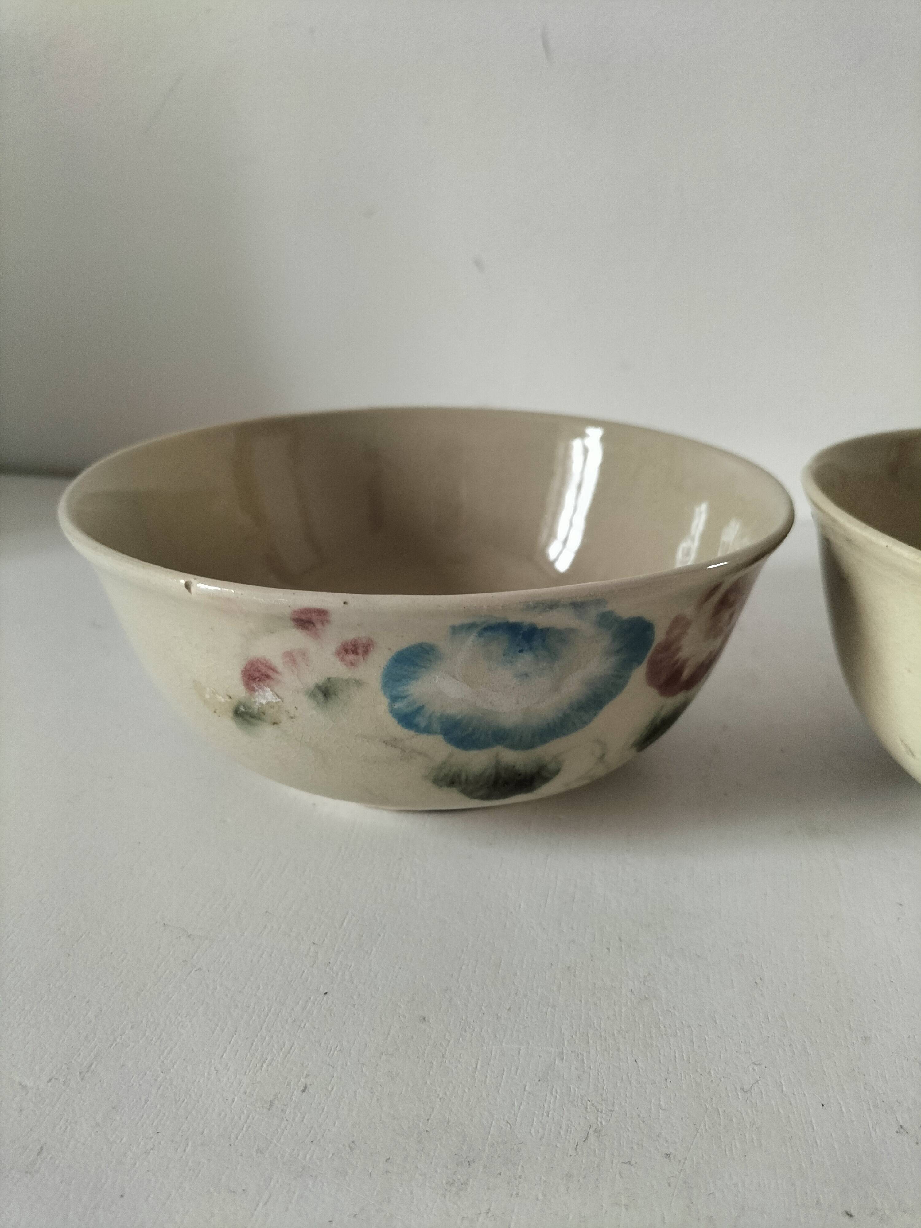 Two large vintage bowls in pastel decor on mini pedestals.
