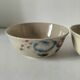 Two large vintage bowls in pastel decor on mini pedestals.