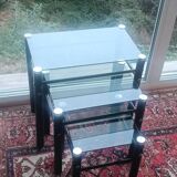 3 nesting tables in black metal with smoked glass tops.