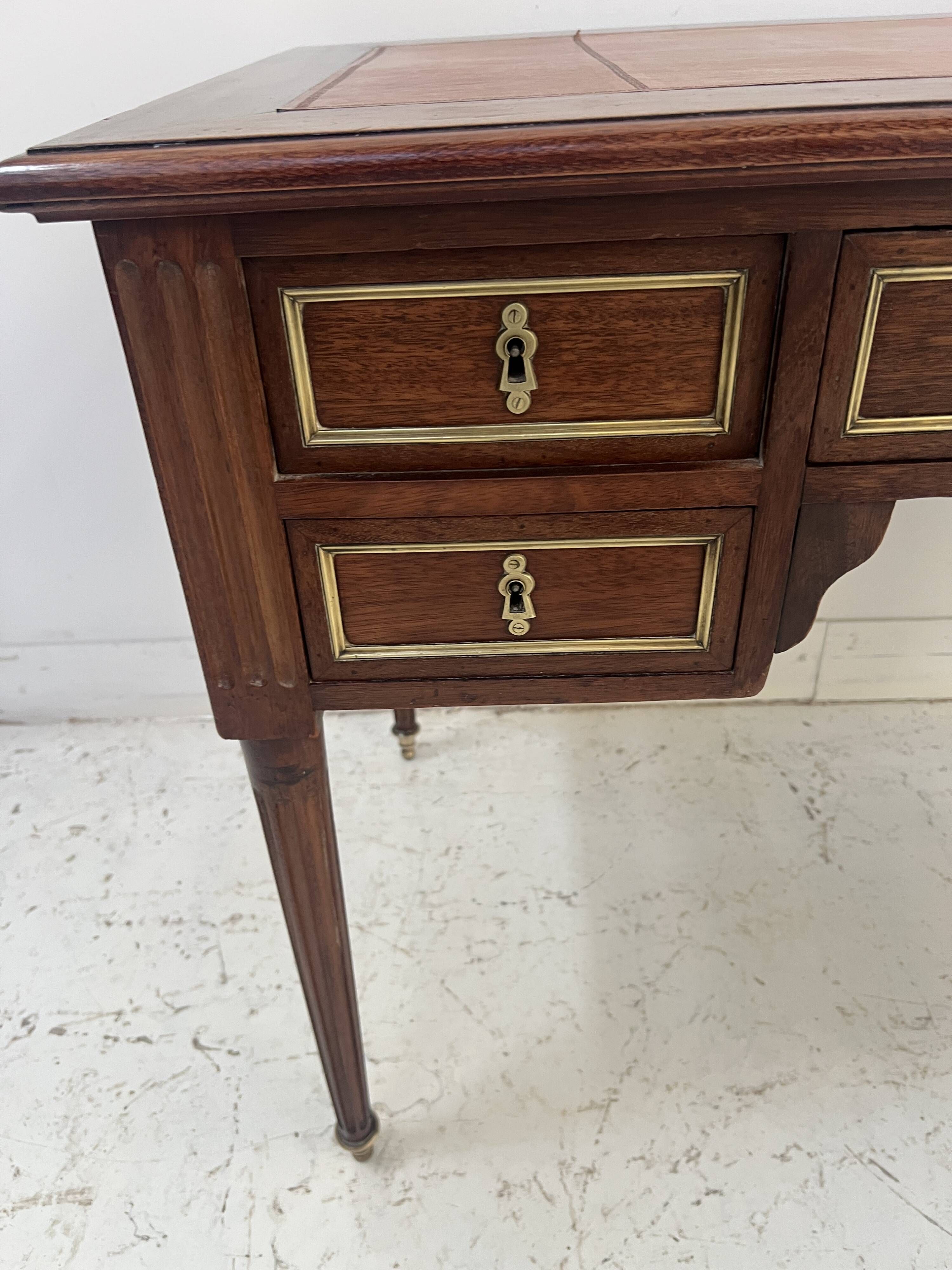 Louis XVI style desk in mahogany and mahogany veneer, 20th century.