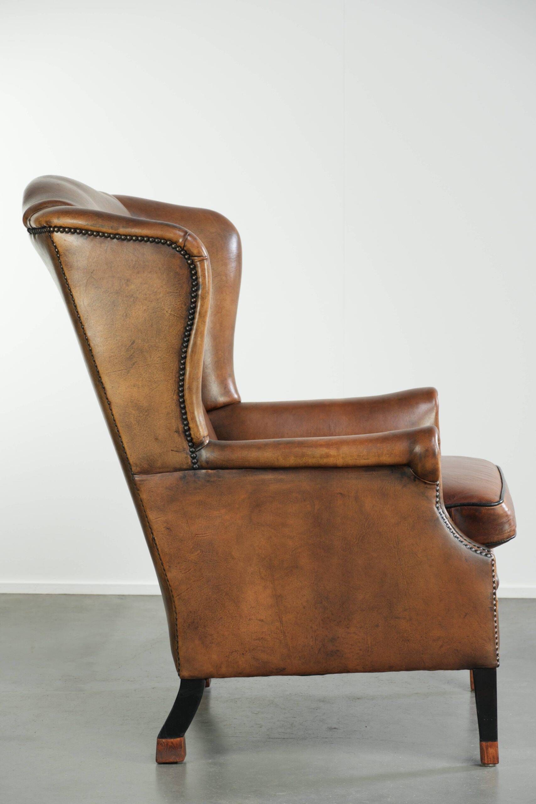 Sheepskin wingback armchair with patina finished with decorative nails