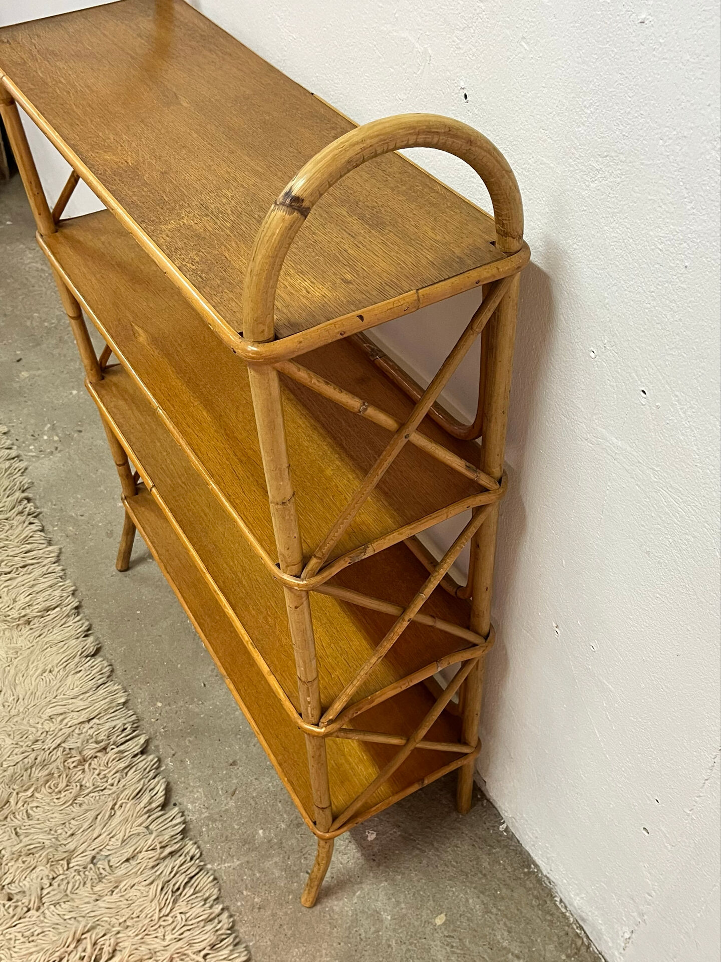 Vintage shelf on legs made of rattan and wood.