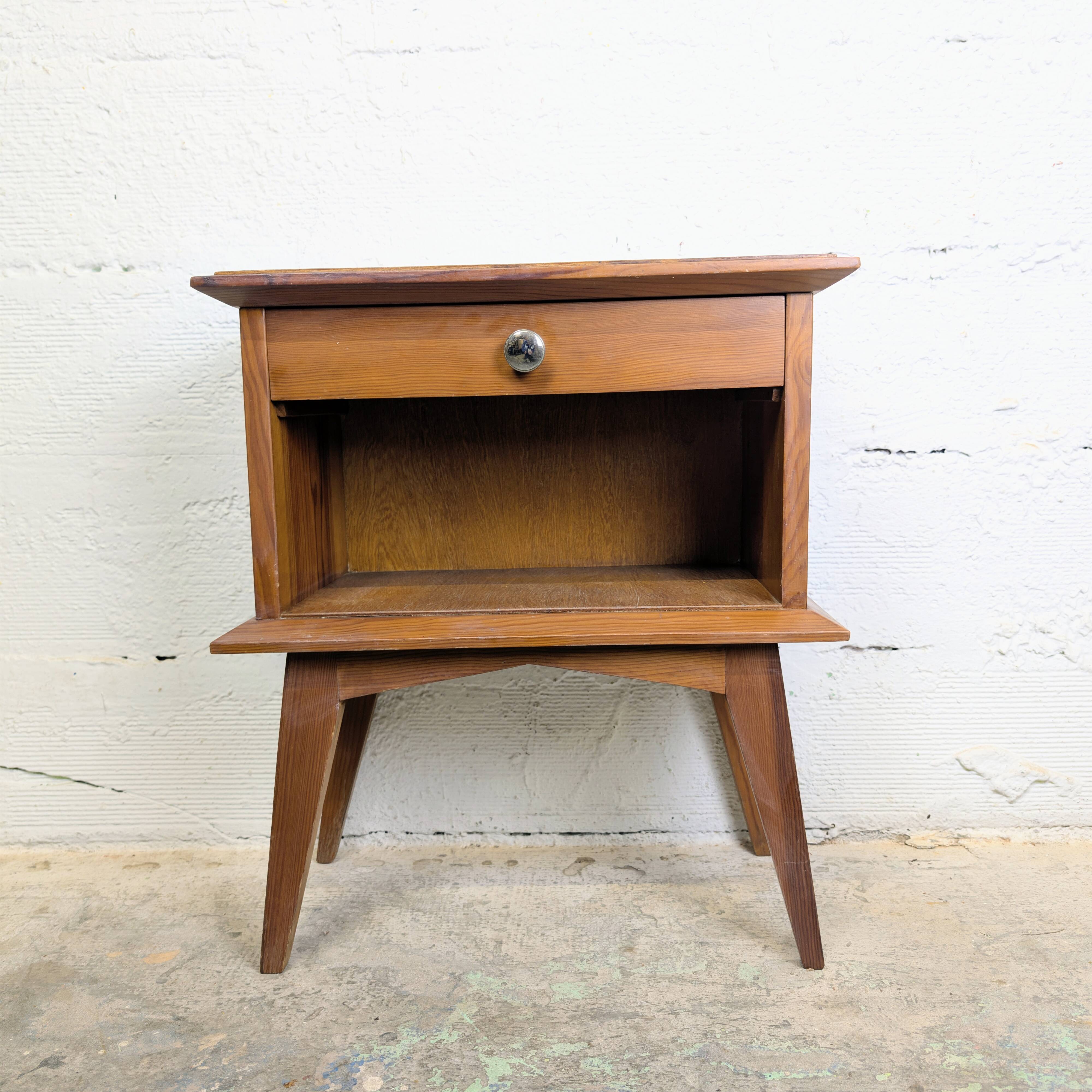 Vintage bedside table with tapered legs.