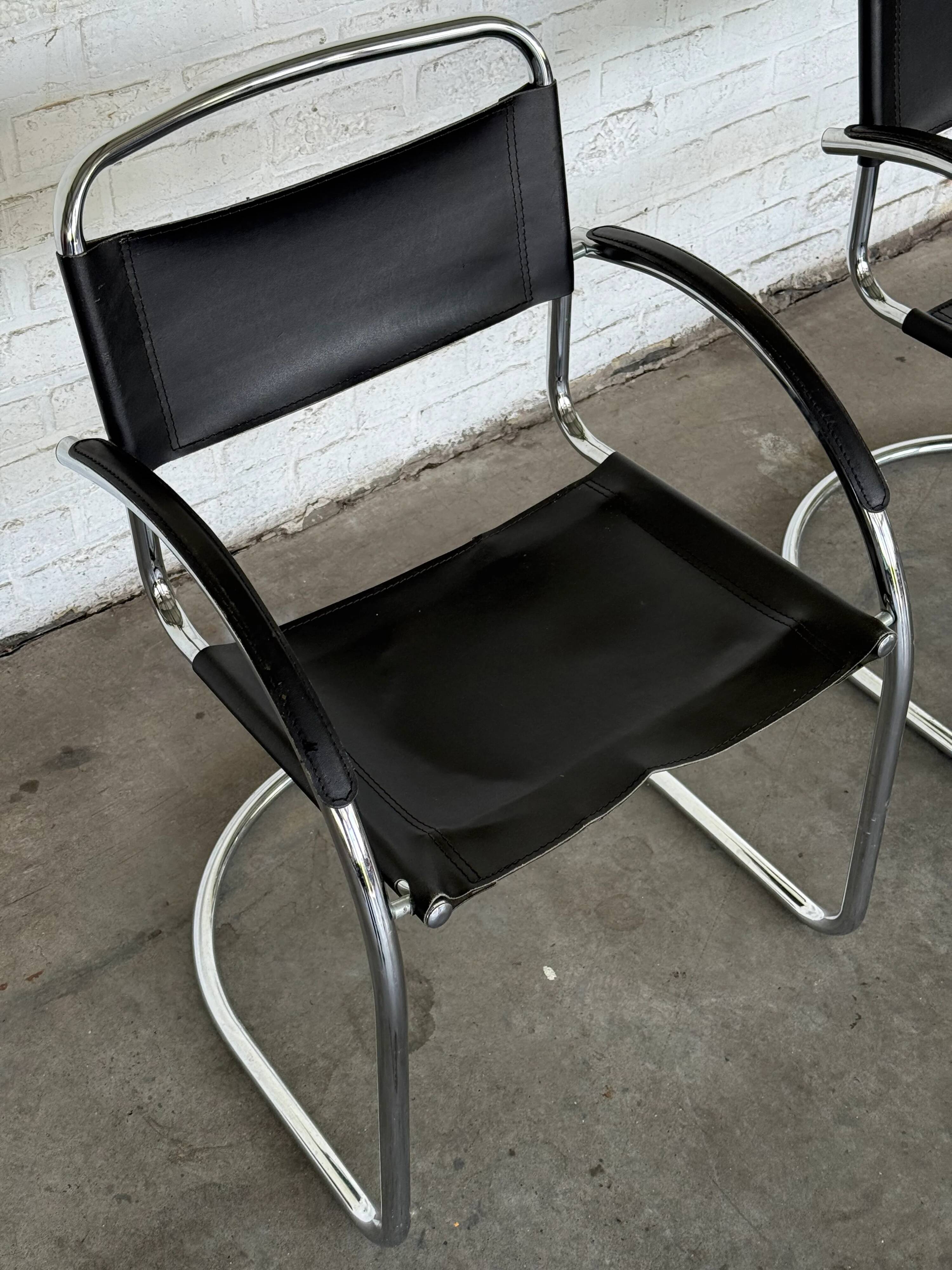 Vintage cantilever chairs in black saddle leather and chrome.