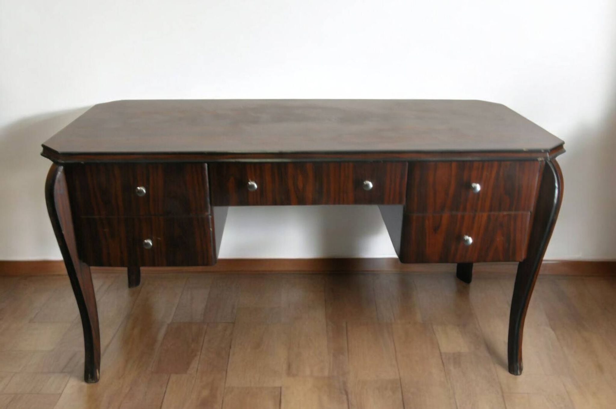 A large Art Deco style rosewood desk with 5 drawers and decorative motifs
