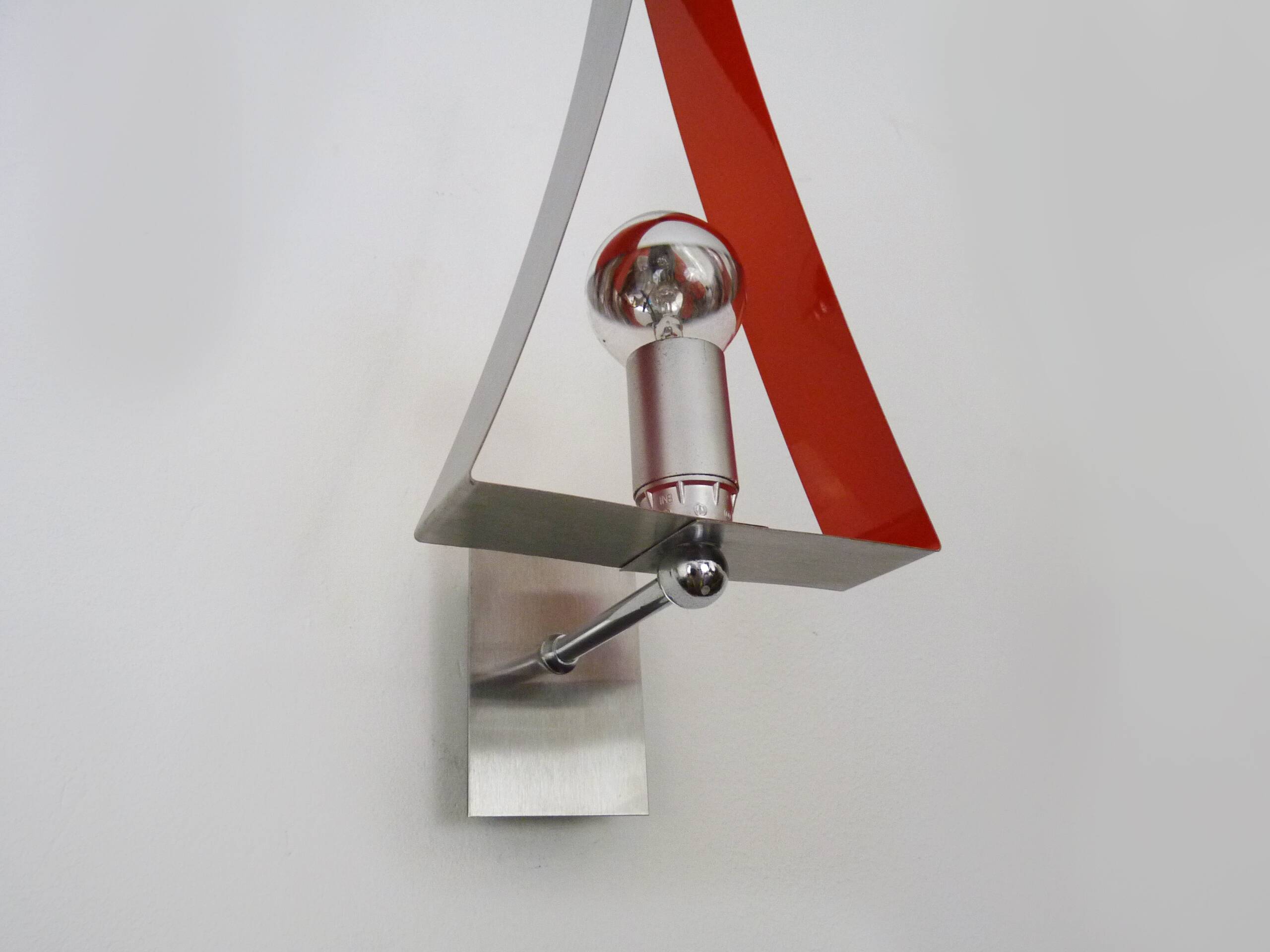 Pair of triangular wall sconces in chrome metal and orange. 1970s.