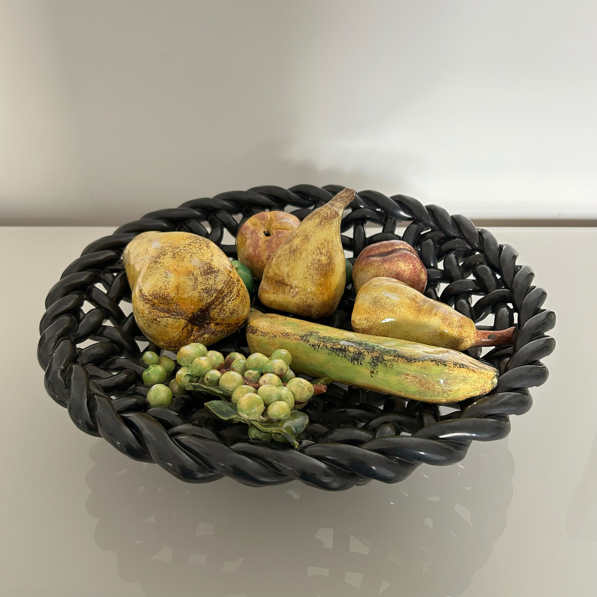 Large woven bowl and trompe l'œil fruits