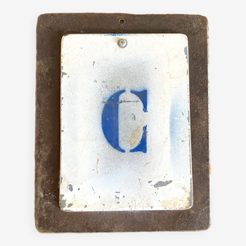 Metal letter C on plate