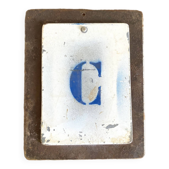 Metal letter C on plate