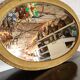 Antique oval mirror with a gilded frame, bevelled glass.