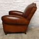 Antique club chair with gendarme hat back