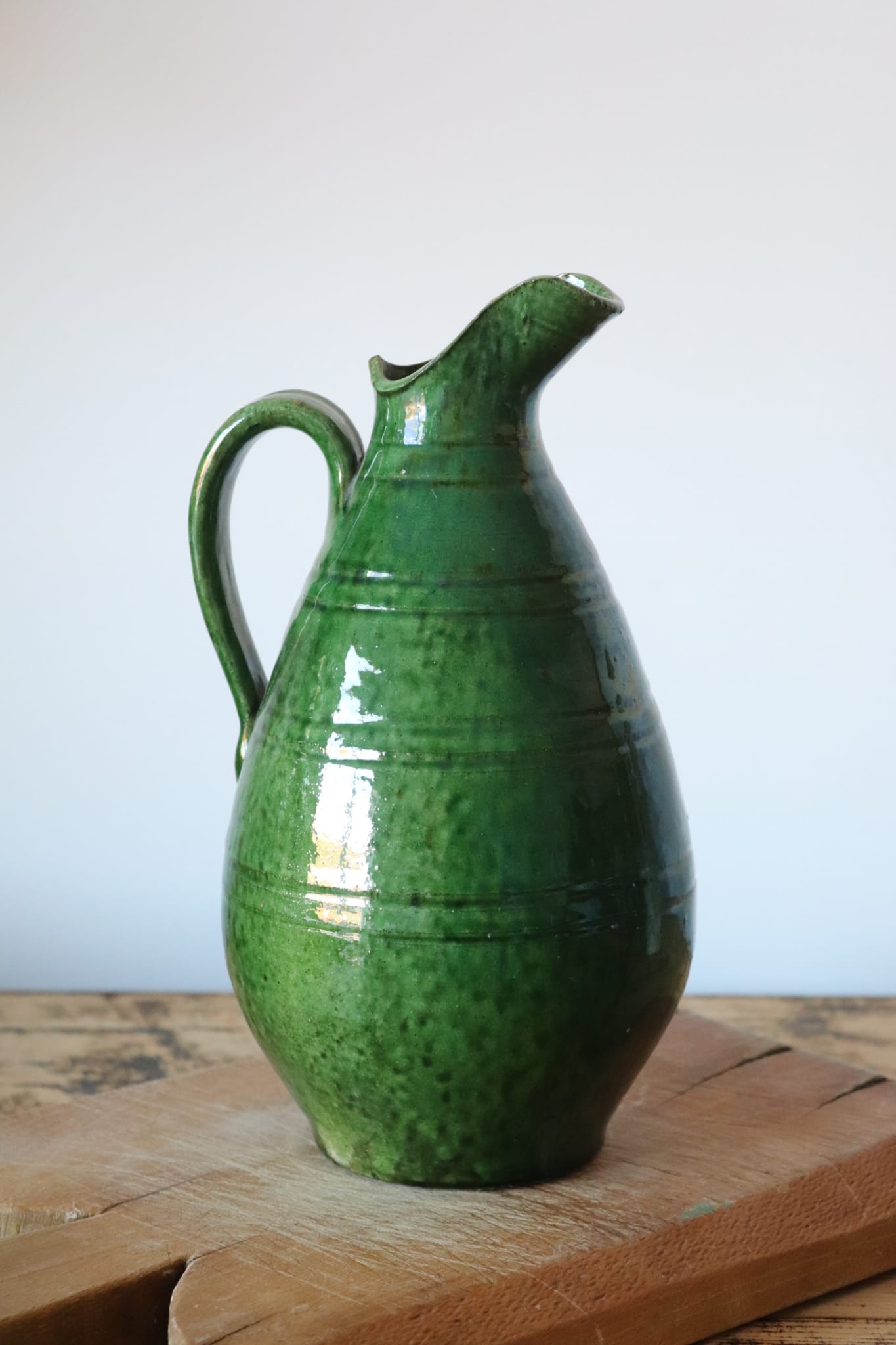 Green old pitcher in glazed terracotta