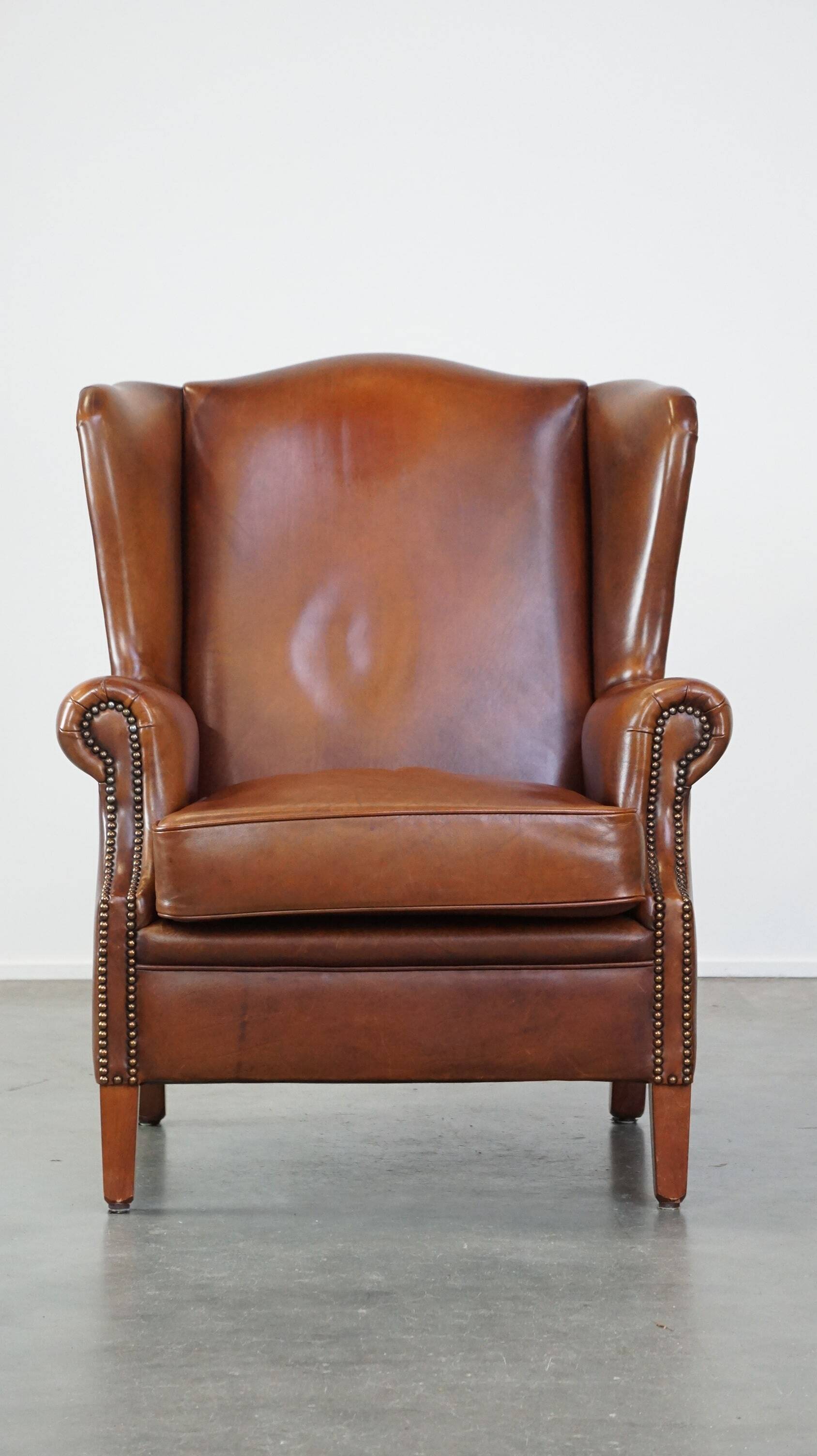 Fauteuil à oreilles en cuir de vachette cognac
