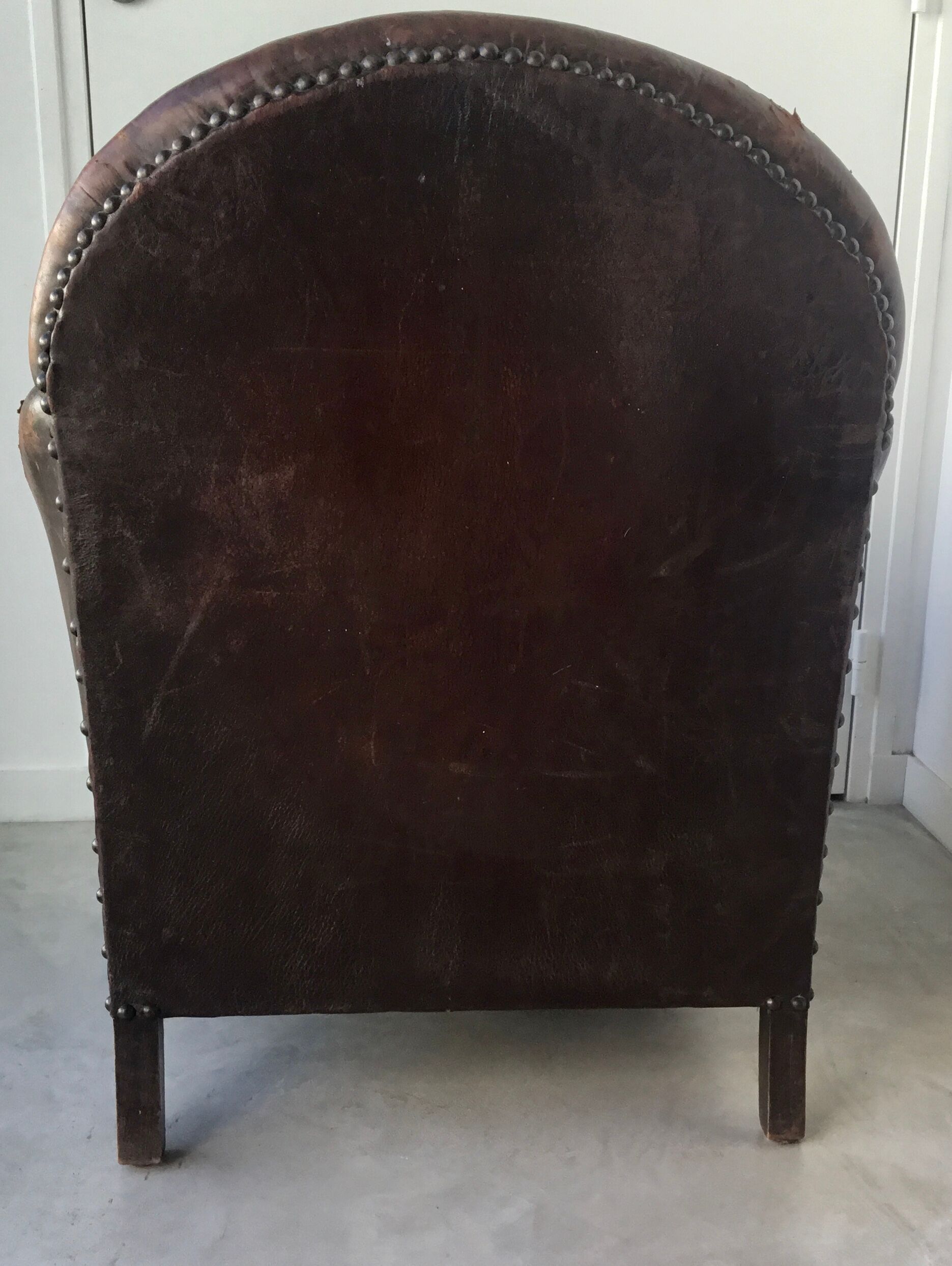 Club armchair in studded leather - early twentieth century