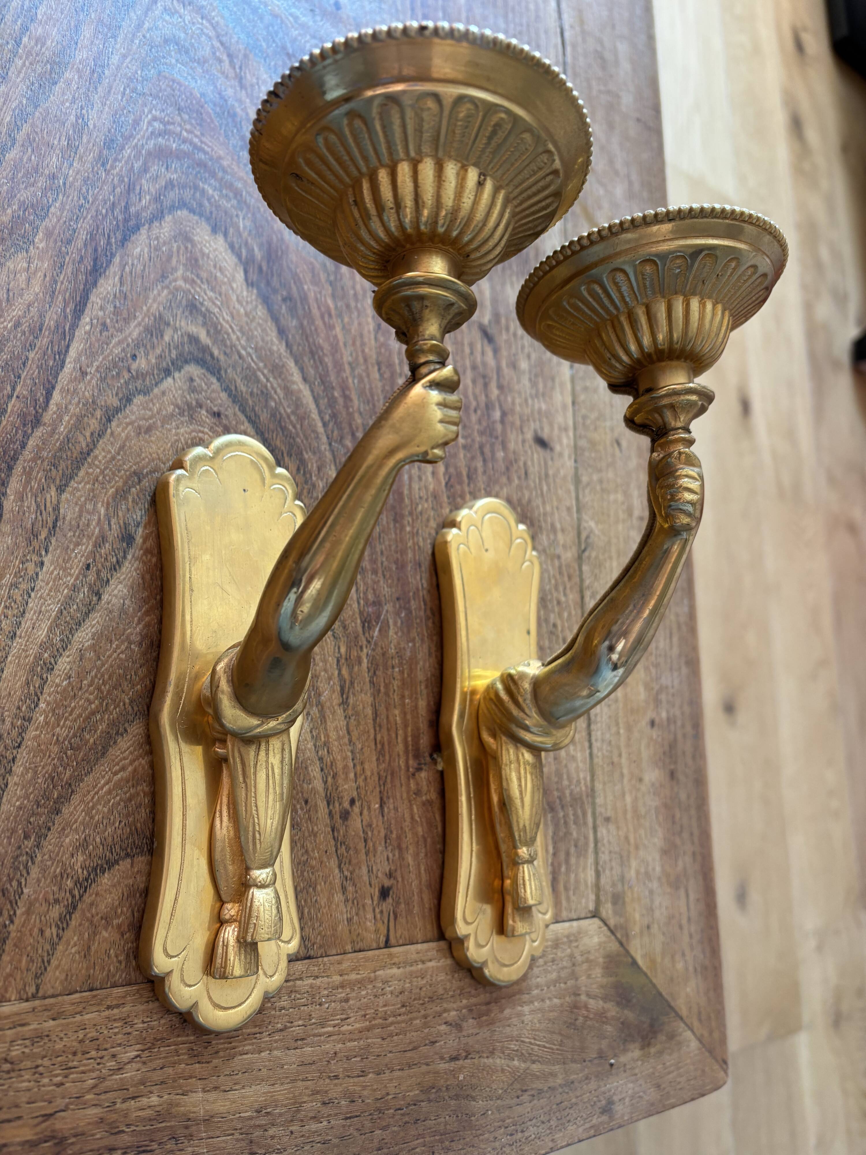 Pair of bronze wall sconces with outstretched arms and hands