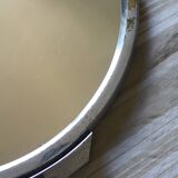 A large round mirror tray with metal handles