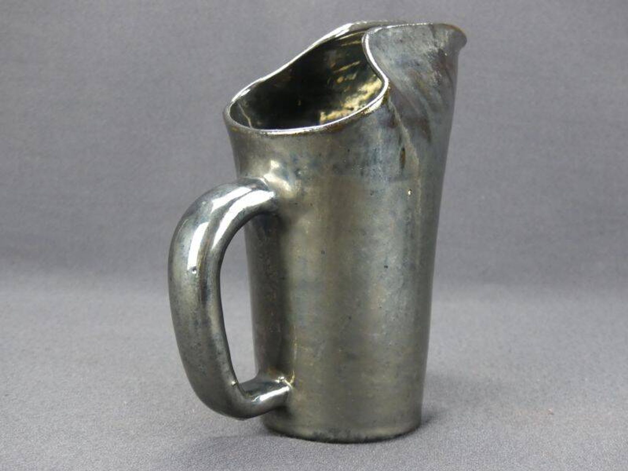 Old Biot, modernist pitcher in iridescent black ceramic.