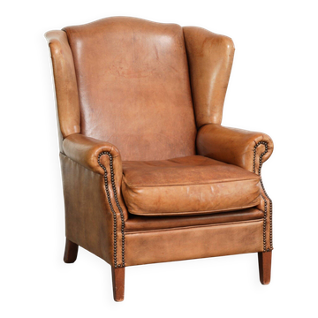 Fauteuil à oreilles en peau de mouton de couleur cognac clair dans le style anglais.
