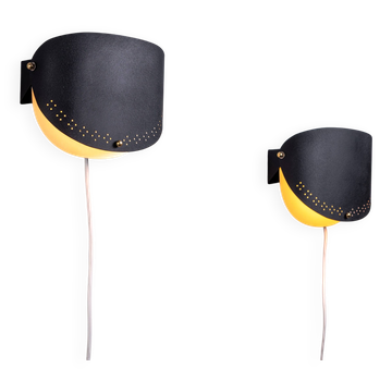 Matte black wall lamps with perforated shades and brass details