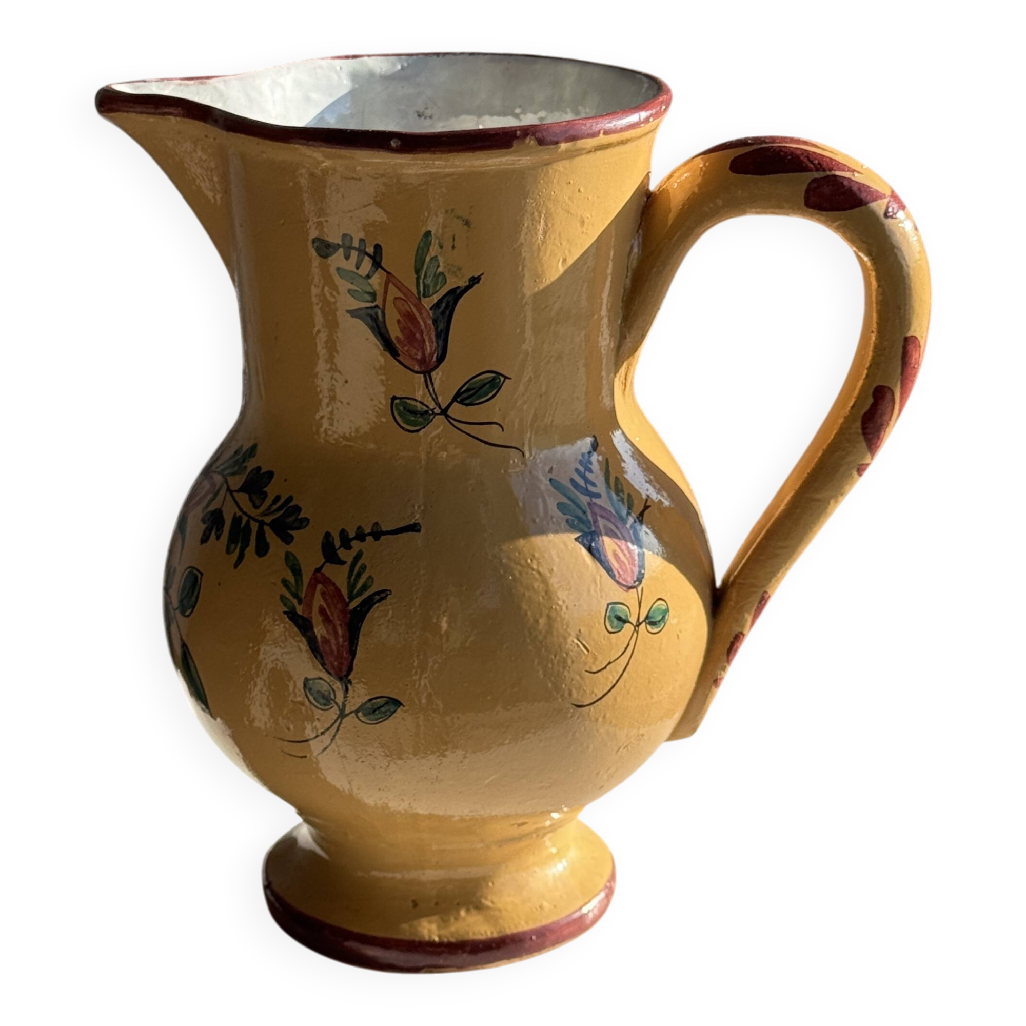 Large antique handmade ochre yellow jug with a pink flower pattern.