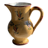 Large antique handmade ochre yellow jug with a pink flower pattern.