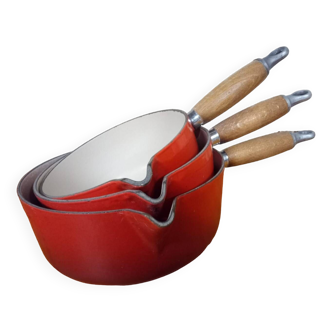 Set of red Le Creuset saucepans