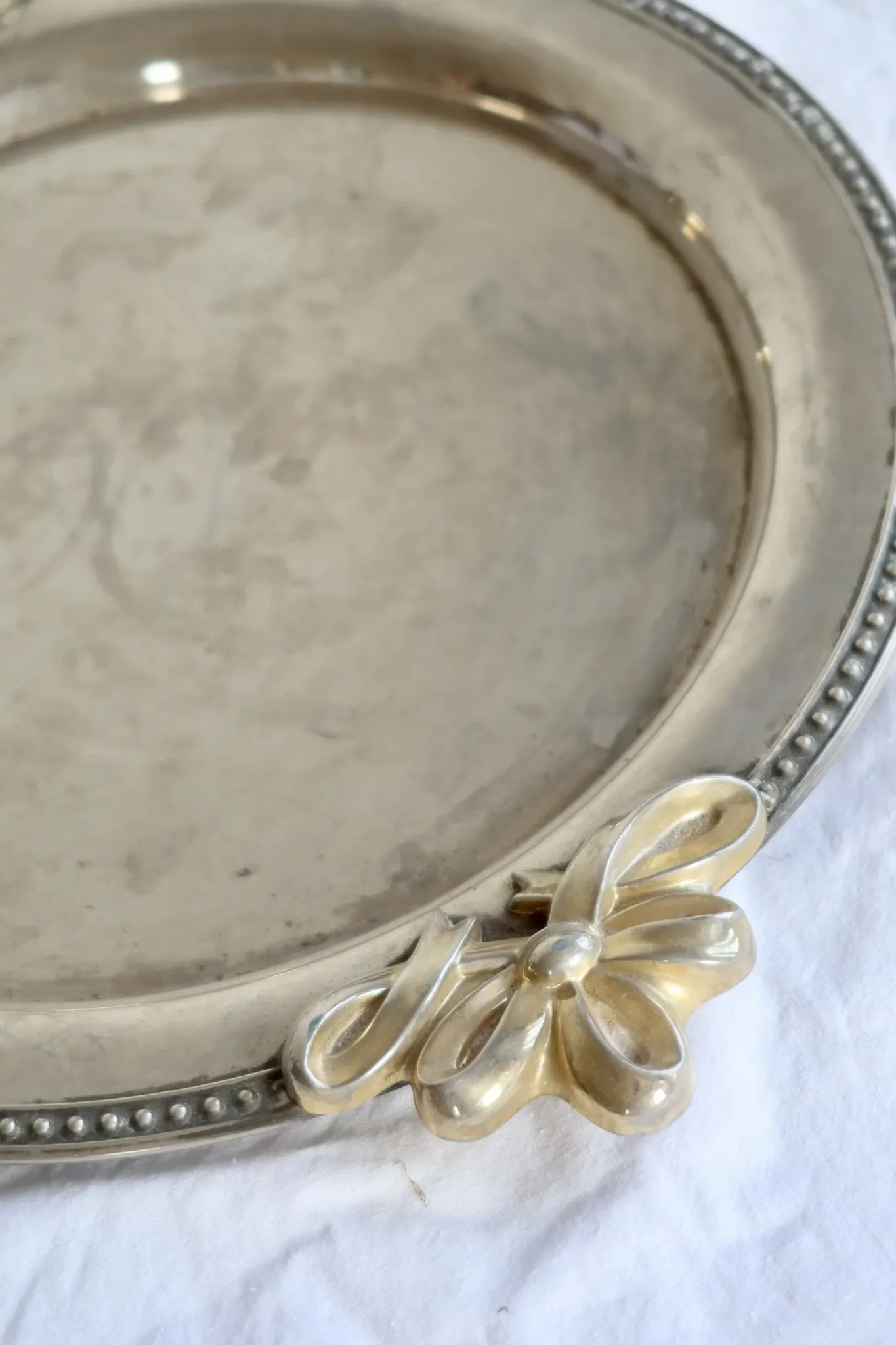 Vintage silver-plated serving tray with bow handles.