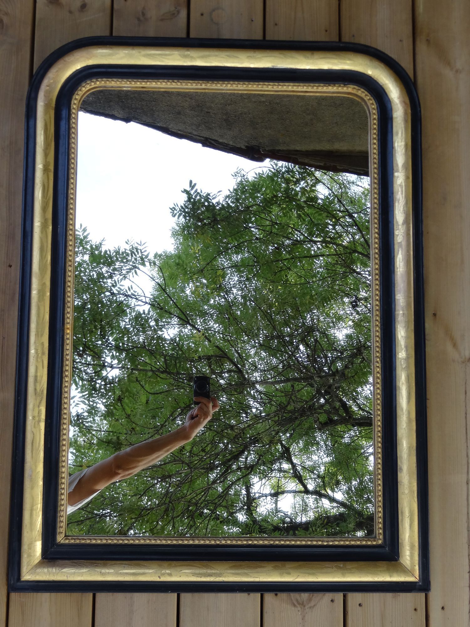 Louis Philippe mirror in blackened and gilded wood, 74 x 102 cm