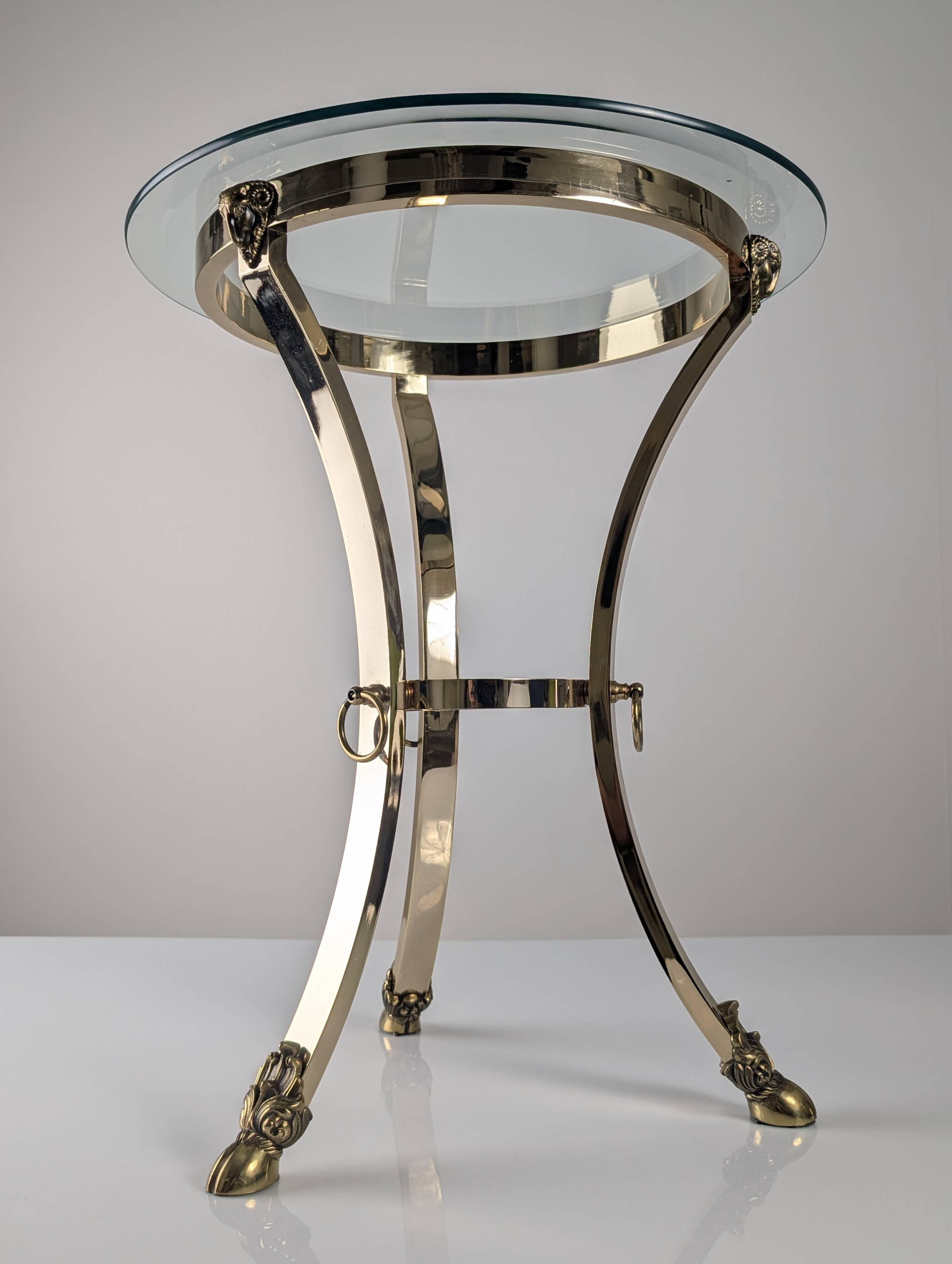 Neoclassical side table in brass and bevelled glass with ram's heads, 1970s.
