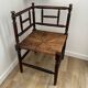 Corner chair made of turned wood with a straw seat.