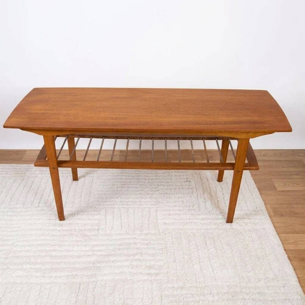 Scandinavian coffee table in teak with a lower shelf and brass bars.